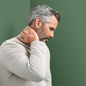 Man with psoriasis on hand holding neck