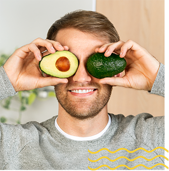 Person holding an avocado up to his eyes