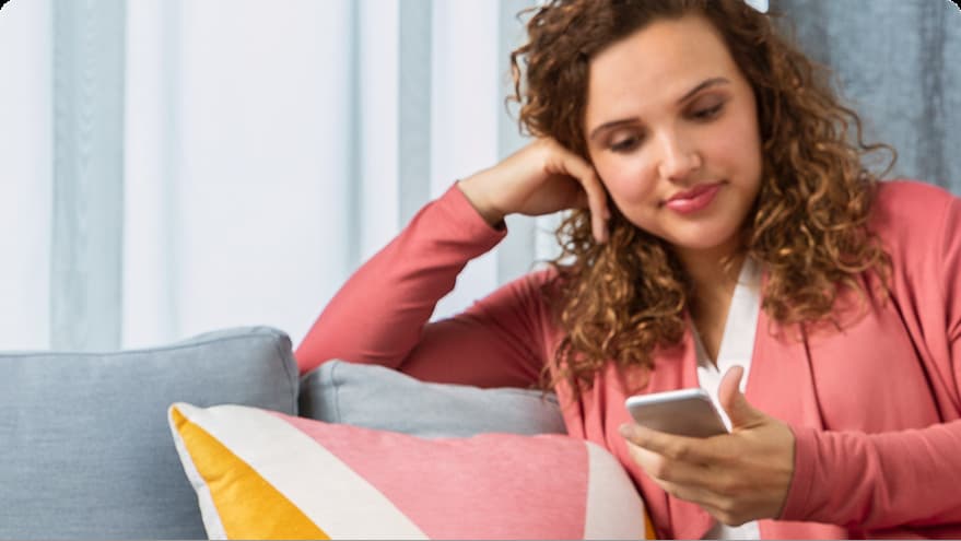 Woman holding phone on couch